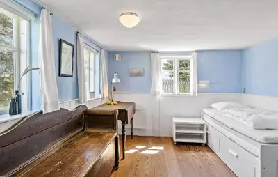 a bedroom with a bed and a desk and windows at 4 Bedroom Nice Home In Blokhus in Blokhus