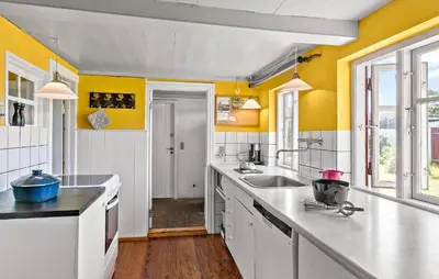 a kitchen with yellow walls and white counter tops at 4 Bedroom Nice Home In Blokhus in Blokhus