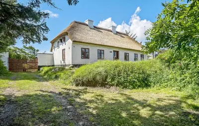an old white house with a thatched roof at 4 Bedroom Nice Home In Blokhus in Blokhus