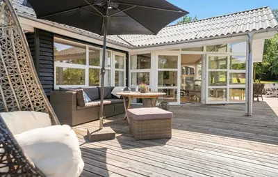 an outdoor patio with a table and an umbrella at Pet Friendly Home In Farsø With Wifi in Farsø