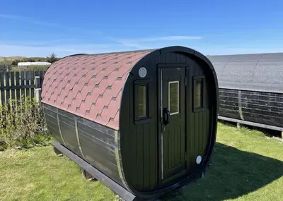 a small green shed with a red roof at Camping Vesterhav in Harboør