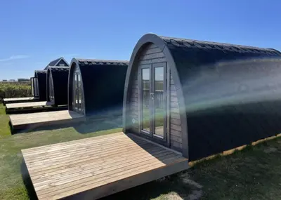 a tiny house with a large window and a wooden deck at Camping Vesterhav in Harboør