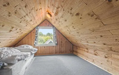 a wooden room with a bed and a window at Beautiful Home In Spøttrup With Kitchen in Spottrup