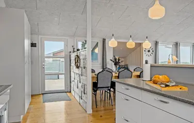 a kitchen with white cabinets and a table with chairs at Nice Home In Lemvig With Wifi in Lemvig