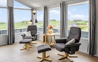 a living room with two chairs and a table and windows at Nice Home In Lemvig With Wifi in Lemvig
