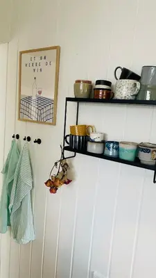 a kitchen with white cabinets and black shelves at Dejligt sommerhus med udsigt over fjorden in Løgstrup