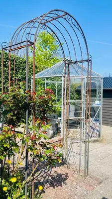 a garden with a greenhouse and a plant at Dejligt sommerhus med udsigt over fjorden in Løgstrup