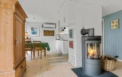 a living room with a fireplace and a dining room at 2 Bedroom Nice Home In Fjerritslev in Fjerritslev