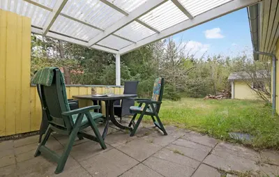 a patio with a table and two chairs under a pergola at 2 Bedroom Nice Home In Fjerritslev in Fjerritslev