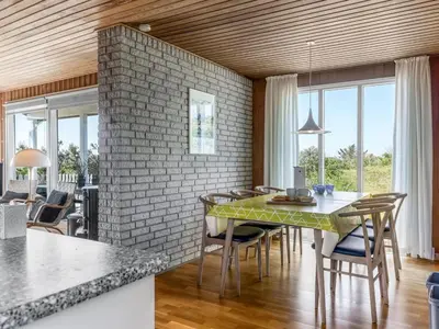 a kitchen and dining room with a brick wall at Holiday Home Letje - 500m from the sea by Interhome in Løkken