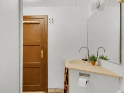 a bathroom with a sink and a brown door at Holiday Home Edvardsine - 20m to the fjord by Interhome in Vestervig