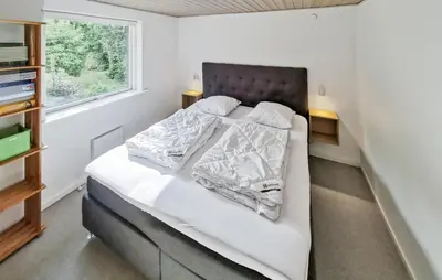 a bedroom with a bed with white sheets and a window at Cozy Home In Spøttrup With Wifi in Spottrup