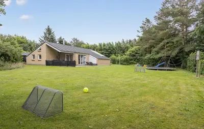 a yard with a house and a ball on the grass at Cozy Home In Spøttrup With Sauna in Spottrup
