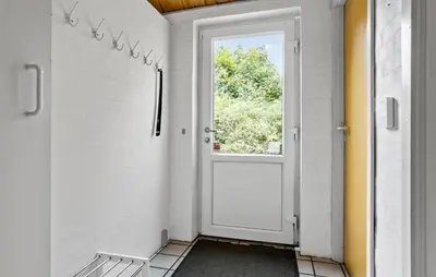 a hallway with a door and a window at Cozy Home In Spøttrup With Sauna in Spottrup