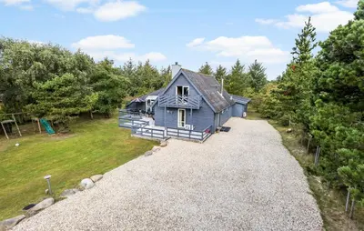 a blue house sitting on top of a gravel road at Stunning Home In Vestervig With Sauna in Vestervig