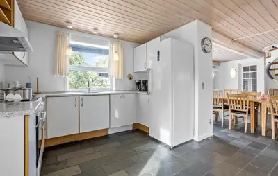 a kitchen with white cabinets and a dining room at Stunning Home In Vestervig With Sauna in Vestervig