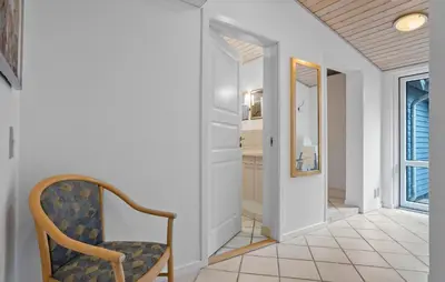 a hallway with a chair and a mirror at Stunning Home In Vestervig With Sauna in Vestervig