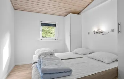 a white bedroom with a bed and a window at Stunning Home In Vestervig With Sauna in Vestervig