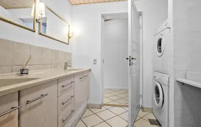 a bathroom with a sink and a washing machine at Stunning Home In Vestervig With Sauna in Vestervig