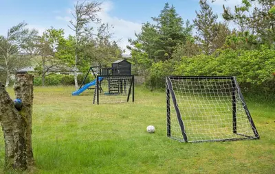 a field with a soccer goal and a playground at 4 Bedroom Beautiful Home In Blokhus in Blokhus