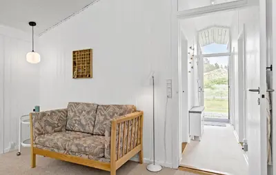a living room with a couch and an open door at 4 Bedroom Beautiful Home In Blokhus in Blokhus