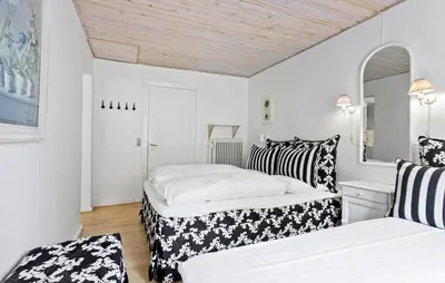 two beds in a room with white walls at Lejl 4 in Brovst