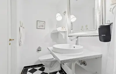 a white bathroom with a sink and a toilet at Lejl 4 in Brovst