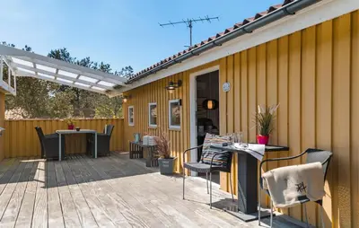 a patio with a table and chairs on a deck at Lovely Home In Thisted With Kitchen in Thisted