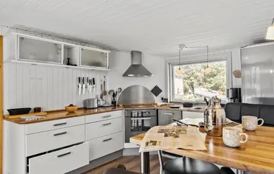a kitchen with white cabinets and a wooden table at Lovely Home In Thisted With Kitchen in Thisted