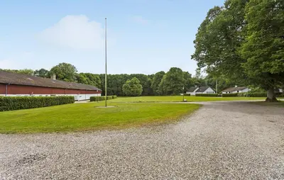 a gravel road next to a building and a pole at Lejl 3 in Brovst
