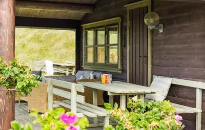 a table and chairs on the porch of a cabin at 2 Bedroom Lovely Home In Saltum in Saltum