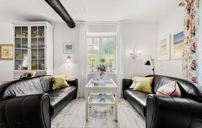 a living room with two leather couches and a table at Lejl 1 in Brovst