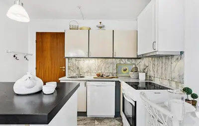 a kitchen with white cabinets and a black counter top at Lejl 1 in Brovst