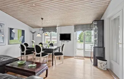 a living room with a table and a dining room at Hus 2 in Brovst