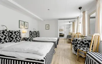 a room with two beds and a table and chairs at Lejl 7 in Brovst