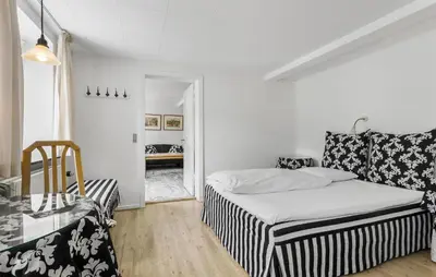 a small bedroom with a bed and a chair at Lejl 7 in Brovst