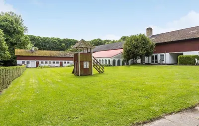 a grassy yard with a playground in front of a building at Lejl 7 in Brovst