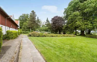 a grassy yard next to a house with a sidewalk at Lejl 2 in Brovst