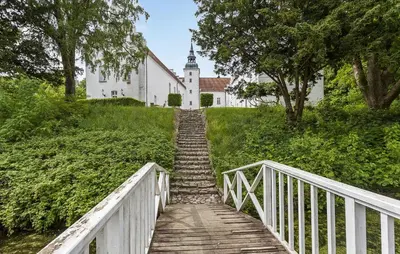 a wooden bridge leading to a church with a building at Lejl 2 in Brovst