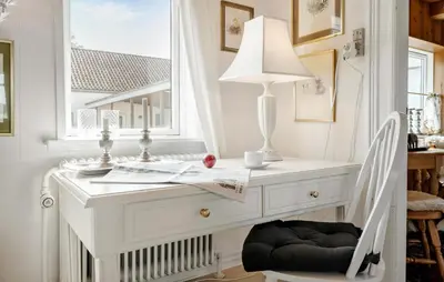 a white desk with a lamp and a chair at Røgegård Gården in Fjerritslev