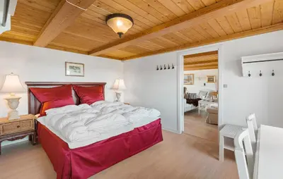 a bedroom with a large bed with red pillows at Røgegård Gården in Fjerritslev