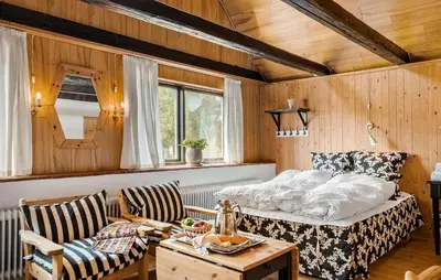 a bedroom with a bed and a table and chairs at Røgegård Gården in Fjerritslev
