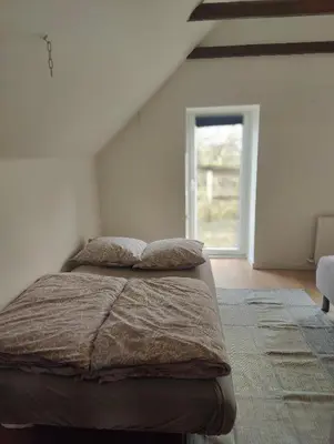 a bed with two pillows in a room with a window at Billig overnatning tæt på badestrand og jesperhus in Roslev