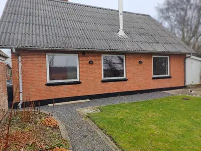 a red brick house with windows and a yard at Billig overnatning tæt på badestrand og jesperhus in Roslev