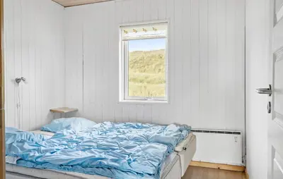 a bed in a white room with a window at Nice Home In Harboøre With Kitchen in Harboør
