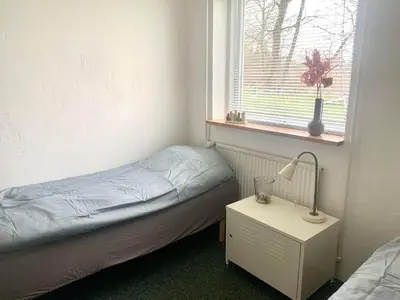 a small bedroom with a bed and a window at Kongshøjgaard in Farsø