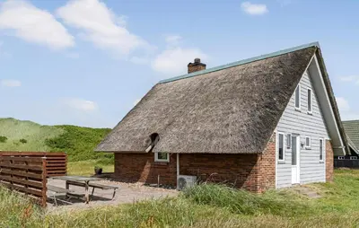 a building with a roof with a bench in front at Cozy Home In Harboøre With Wifi in Harboør