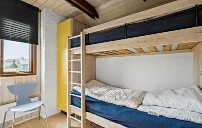 a bunk bed in a room with a desk and a chair at Cozy Home In Harboøre With Wifi in Harboør