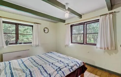 a bedroom with a bed and two windows at 6 Bedroom Gorgeous Home In Bedsted Thy in Bedsted Thy