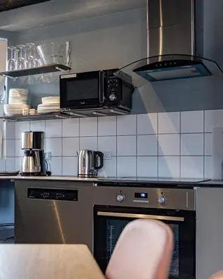 a kitchen with a microwave and a stove top oven at Fun Art Blokhus in Blokhus